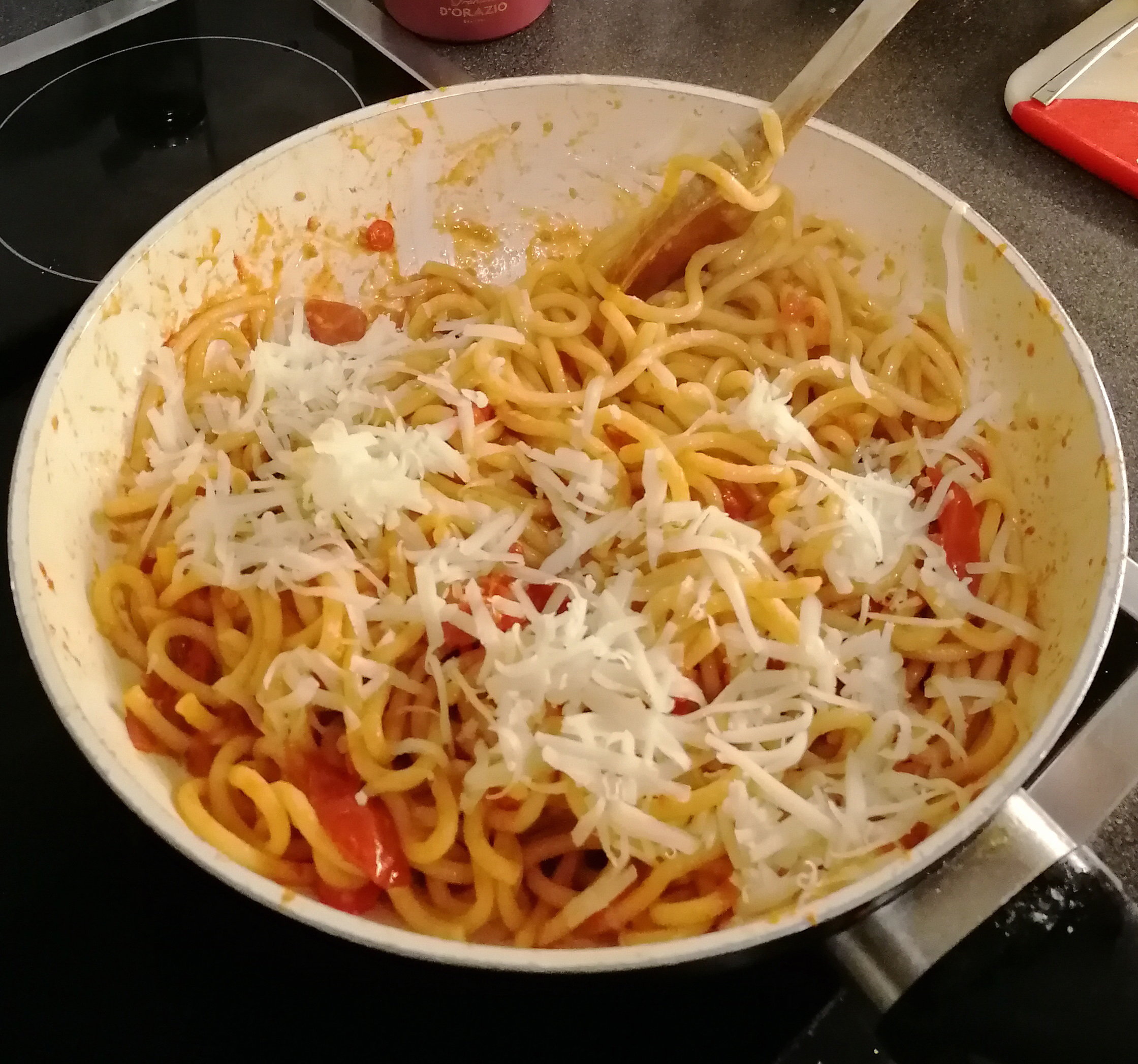 Die fertig gekochten Pici und reichlich Parmesan hinzufügen